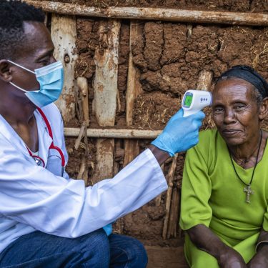 Doctor measuring body temperature with digital thermometer, East Africa